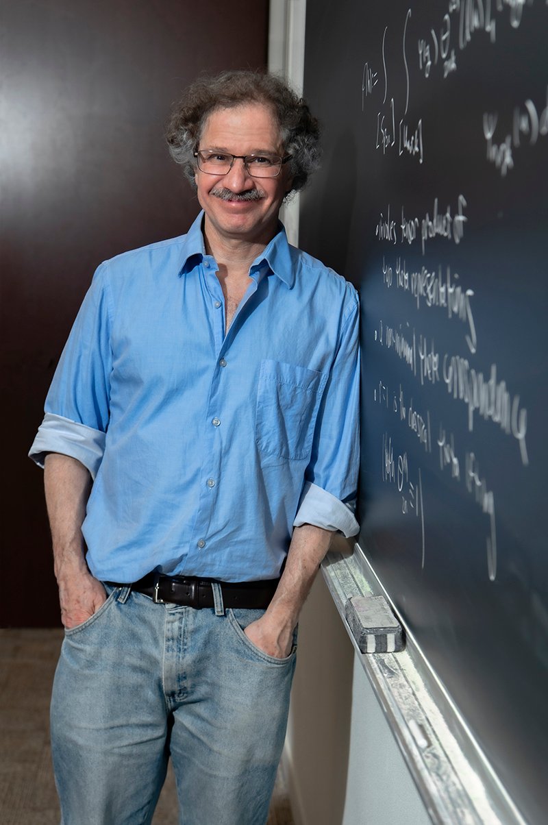 A man in front of a blackboard