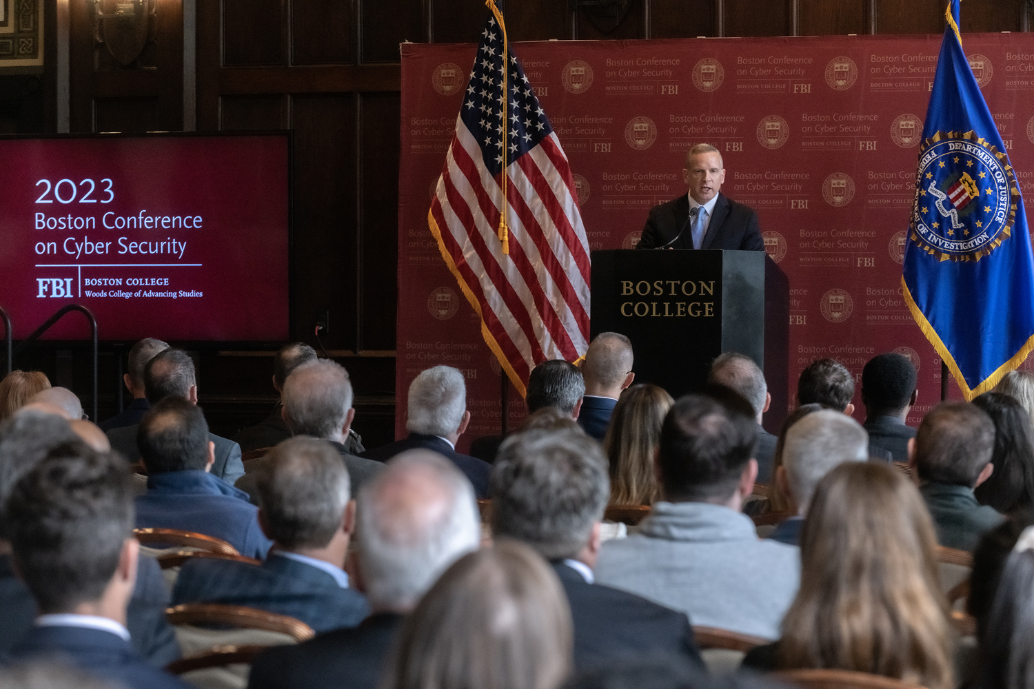 FBI director at podium, flanked by BC and FBI flags