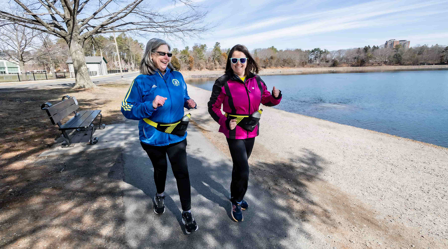 Two women walking along reservoir