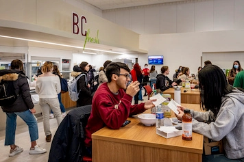 BC students enjoying a meal in a busy dining hall.