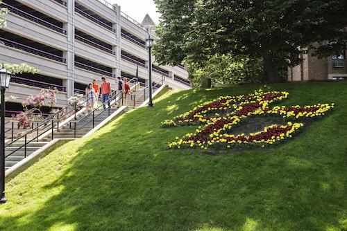 Campus visitors descending stairs adjacent to the parking garage and the BC icon in flowers on the hillside next to Ignacio Hall. Photographed for use in the Fall '18 issue of BCM. Visitors are the Creixell family from Houston, TX. Family members are Marisa, Jordi, Ramon, Monica and Marco. marisacreixellv@gmail.com. 210 Paul Revere Dr., Houston, TX 77024.