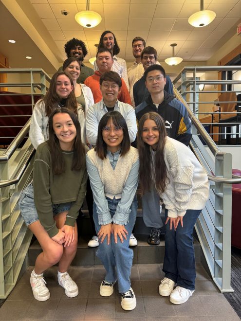 Grimaud research group standing on stairs of Merkert Chemistry Center