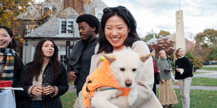 student smiling holding dog