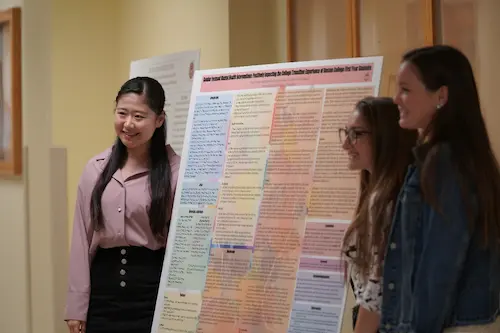 Boston College first-year students presenting a design-thinking project poster as part of the Experience, Reflection, and Action (ERA) program.