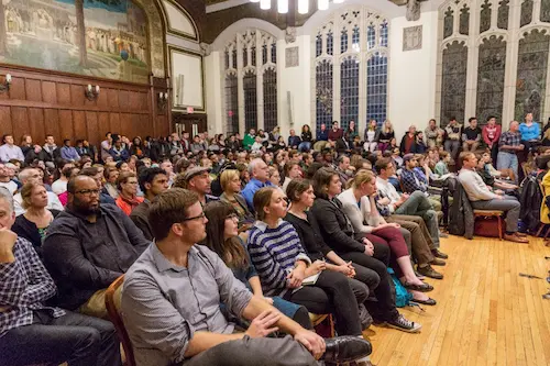 Large seated audience attending a conference at Boston College.