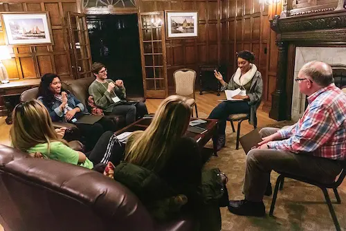 Boston College students and faculty seated in a circle during a Halftime Retreat discussion