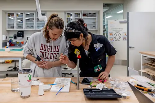 Two Boston College students working together on a hands-on project in a makerspace lab