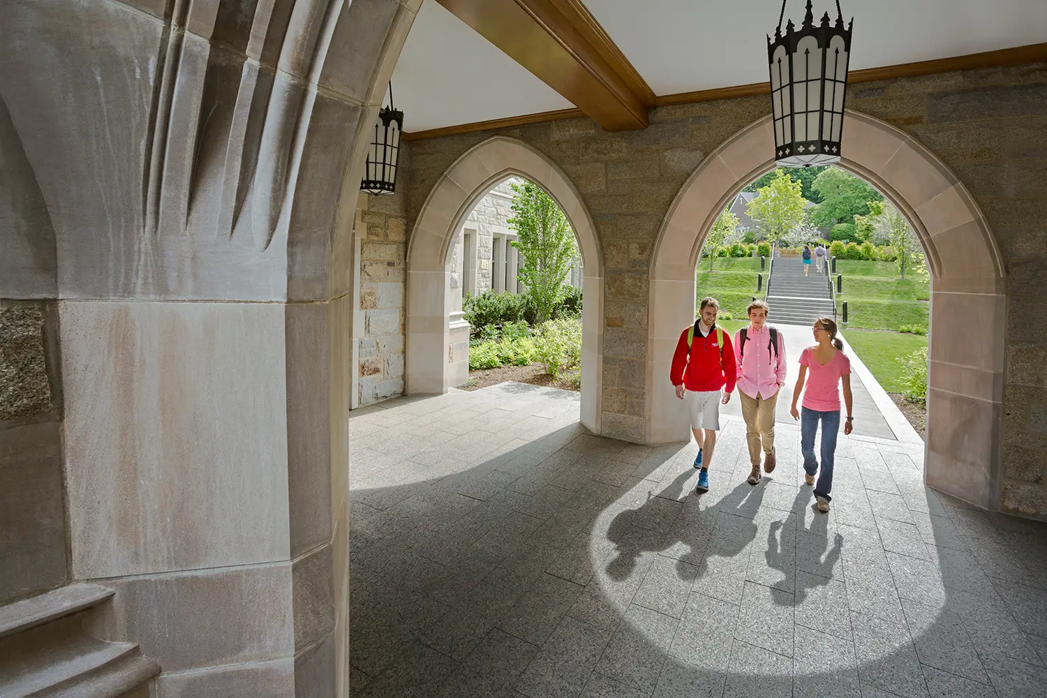 Graduate student walking through Stokes Hall arches