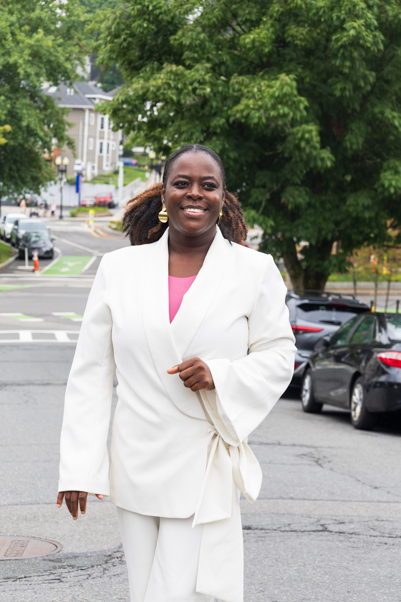 A photo of Portia Agbo walking down the street in a white suit.