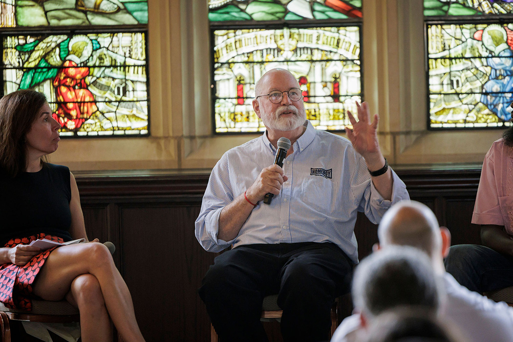 Framed by a big stained glass window, Father Gregory Boyle speaks at 100 Gasson Hall.
