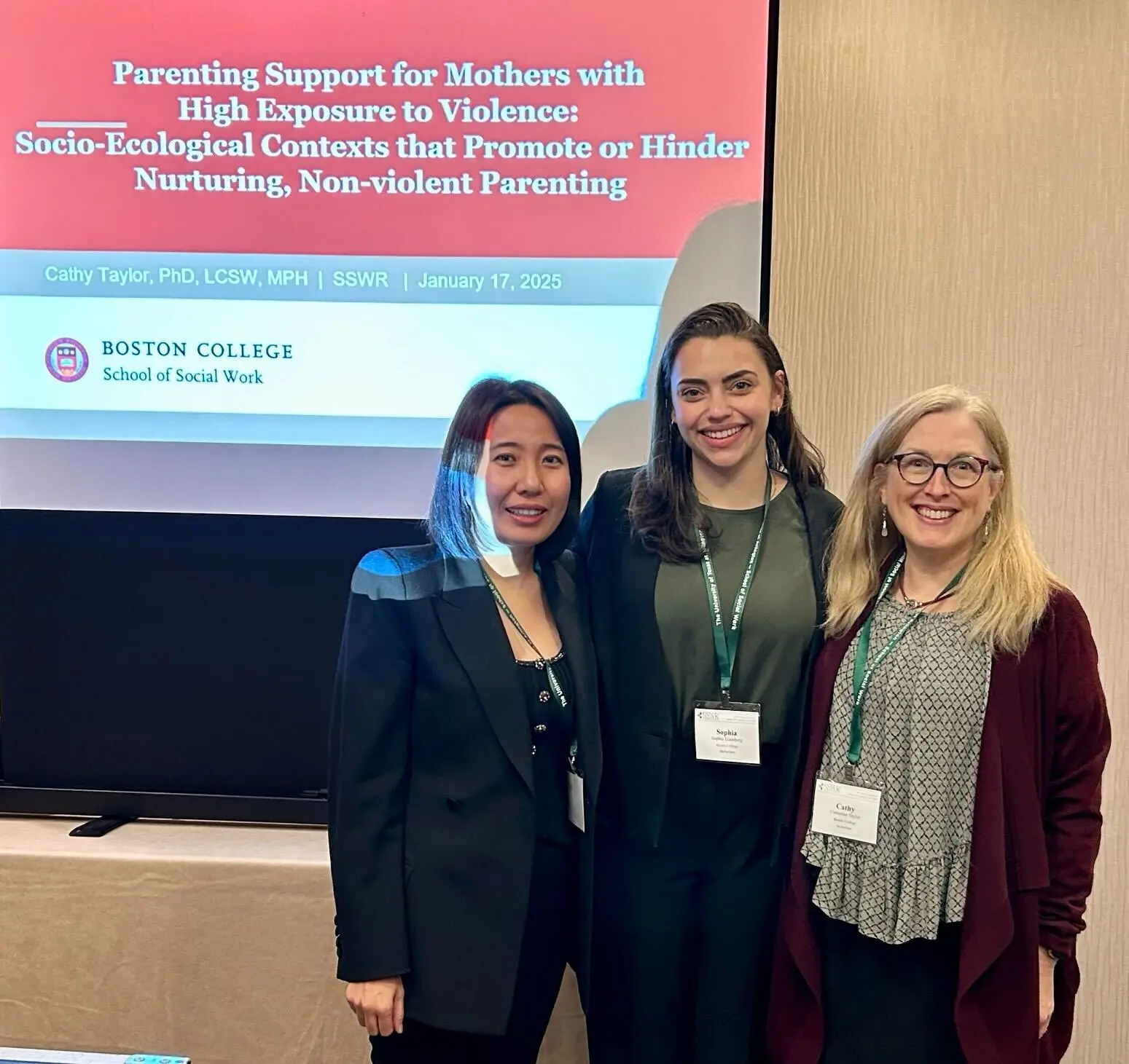 Three CABHRI lab members posing for a photo in front of a presentation.