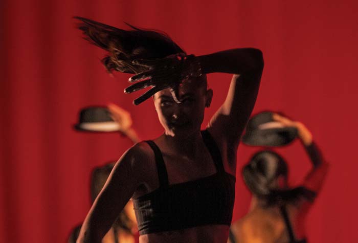 Photo of dancer in silohuette with three dancers in the background