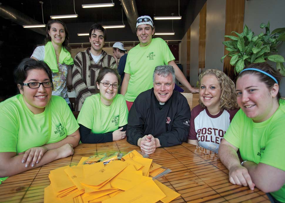 Fr. Butler at table with students around him