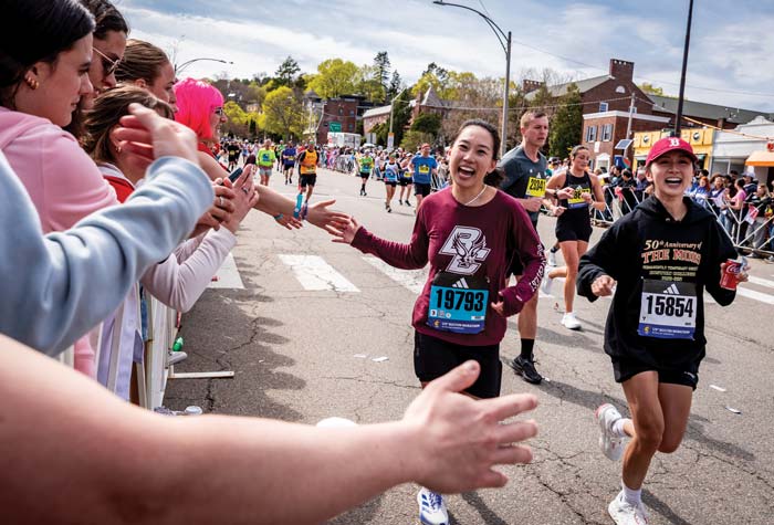 Runner high fiving a cheering crowd