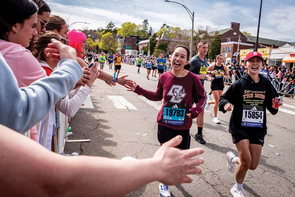 Runner high fiving a cheering crowd