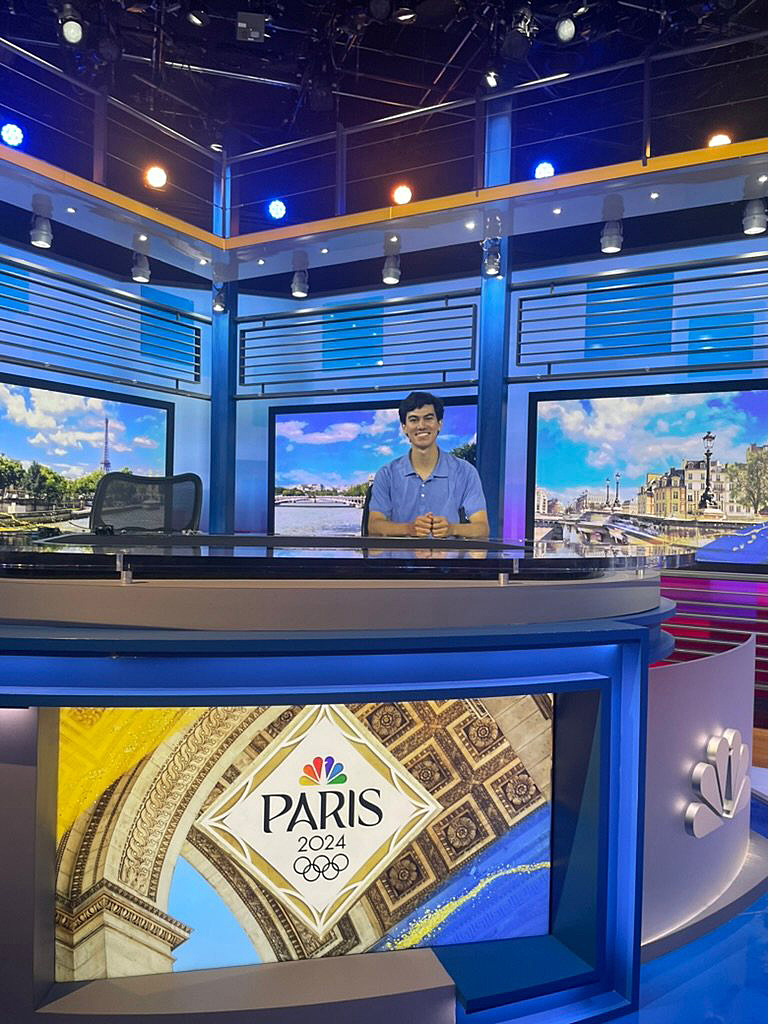 A student sitting at a studio desk at NBC