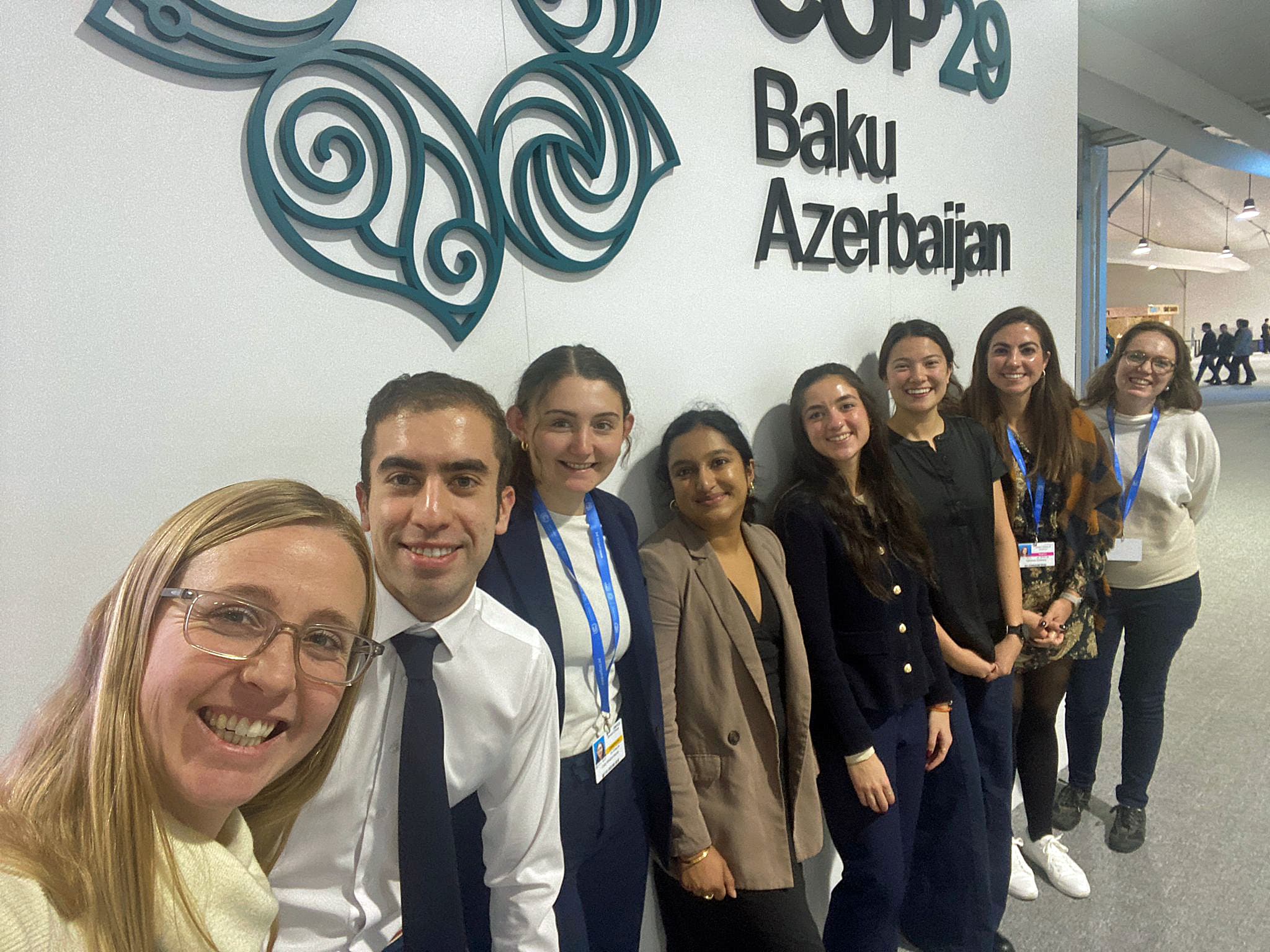 delegates in front of a COP29 sign