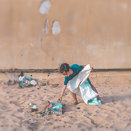 child picking up plastic trash