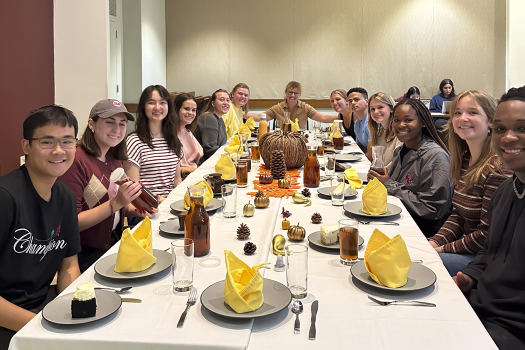 students gathered around a table with a faculty member