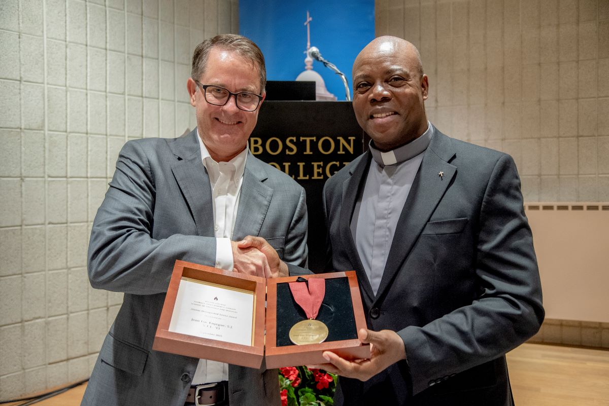 Jean Luc Enyegue, S.J., receives award from CSTM Dean Mick McCarthy, S.J.
