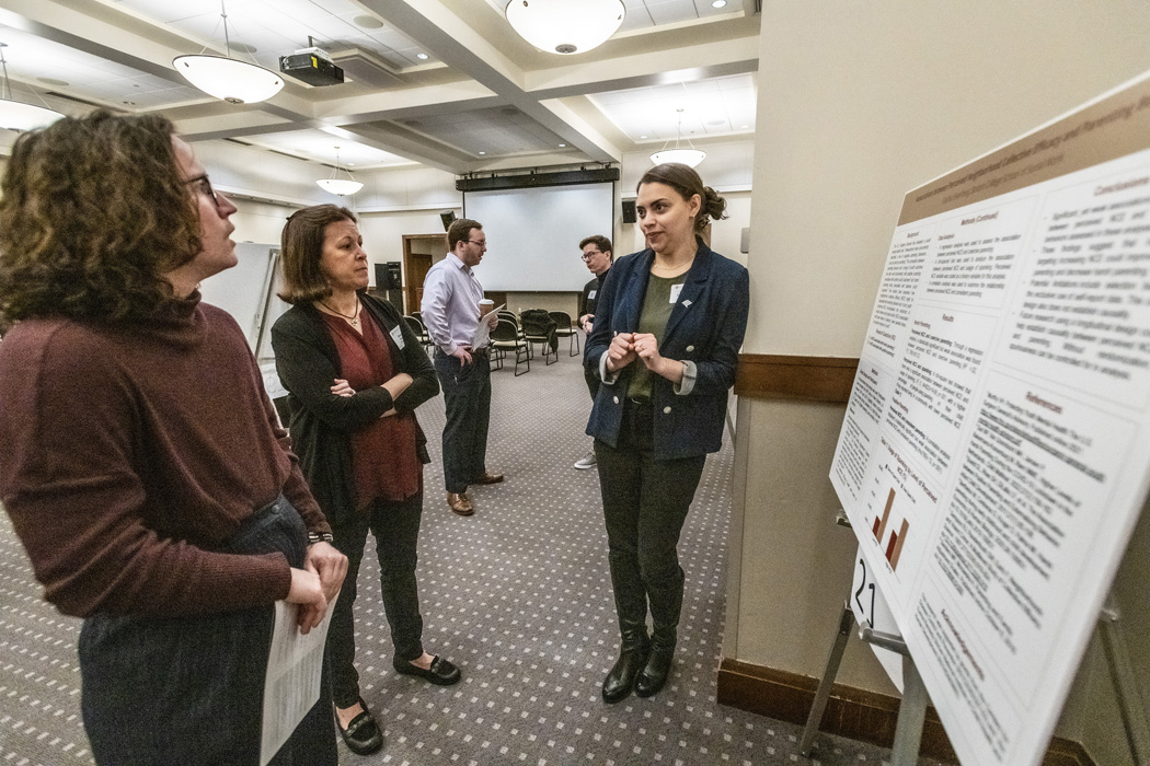 a student presents research to onlookers
