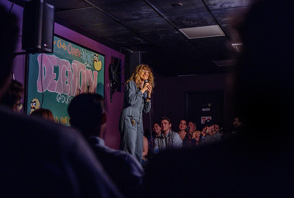 A woman performing stand-up on stage