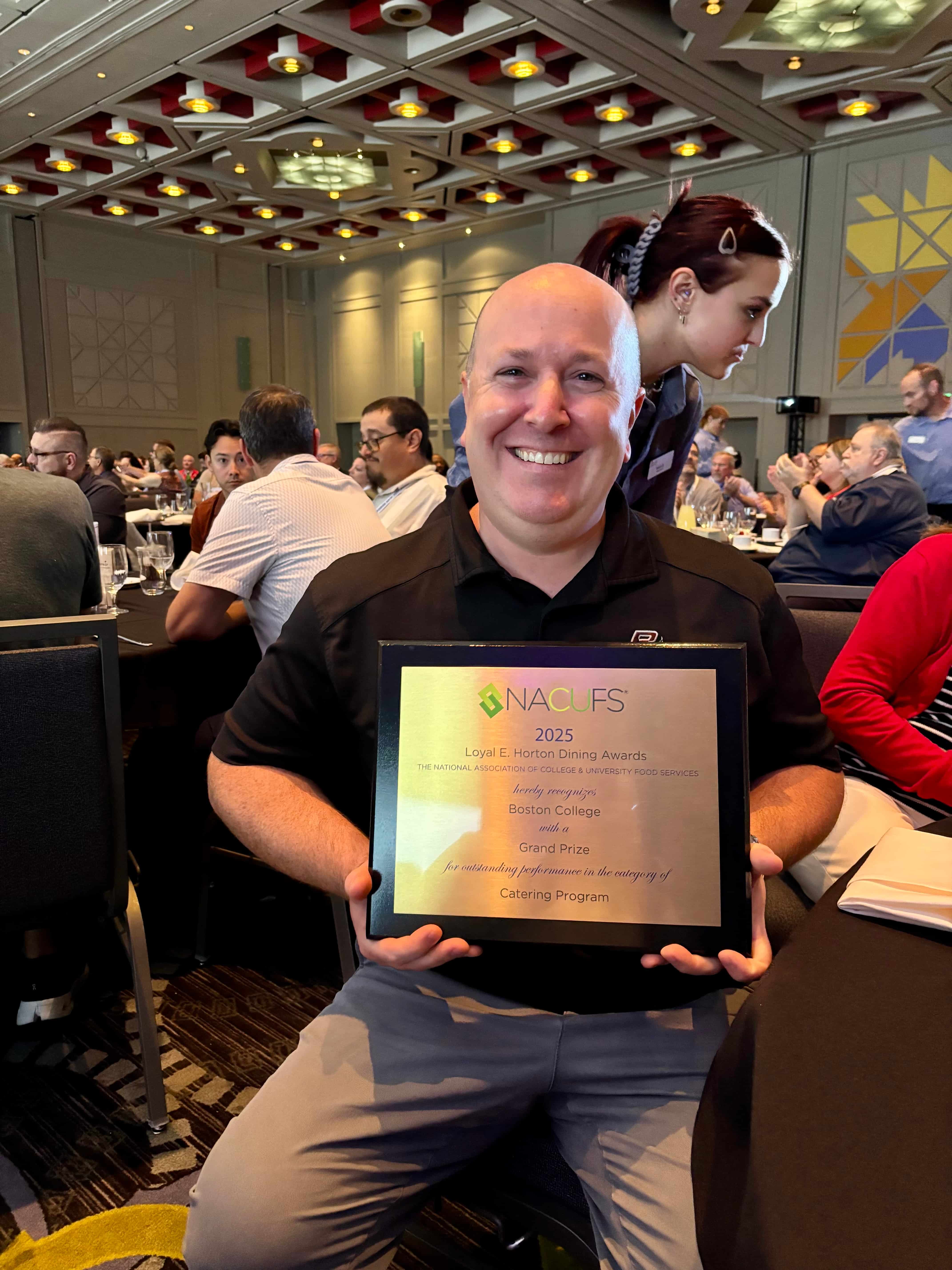 Scott Powers holding a plaque