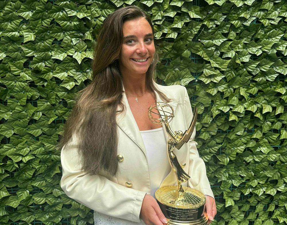 A woman holding a gold trophy