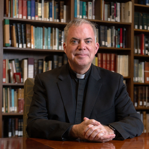 Casey Beaumier, S.J., Director, Institute for Advanced Jesuit Studies and Vice President & University Secretary photographed in an  IAJS library in Simboli Hall.