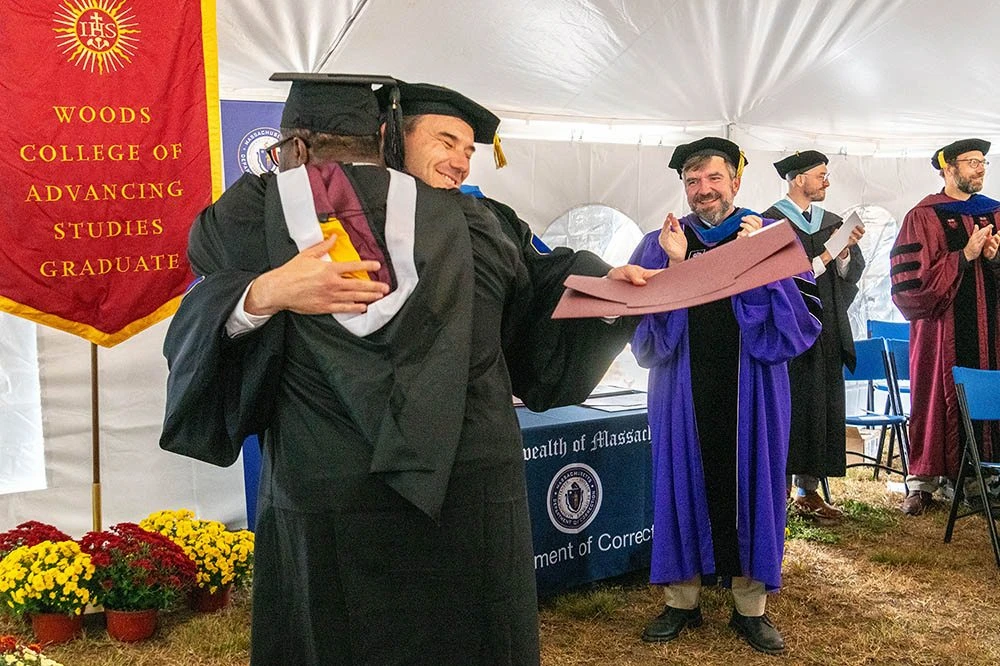 Two people hugging at a graduation ceremony